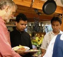 Fr. Ranjan D'Sa, with Bob Lewis on his left, at the potluck lunch.